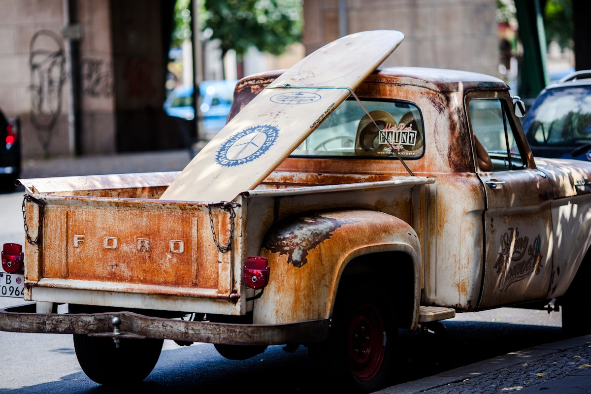 vintage brown and white Ford single-cab pickup truck parked on pavements