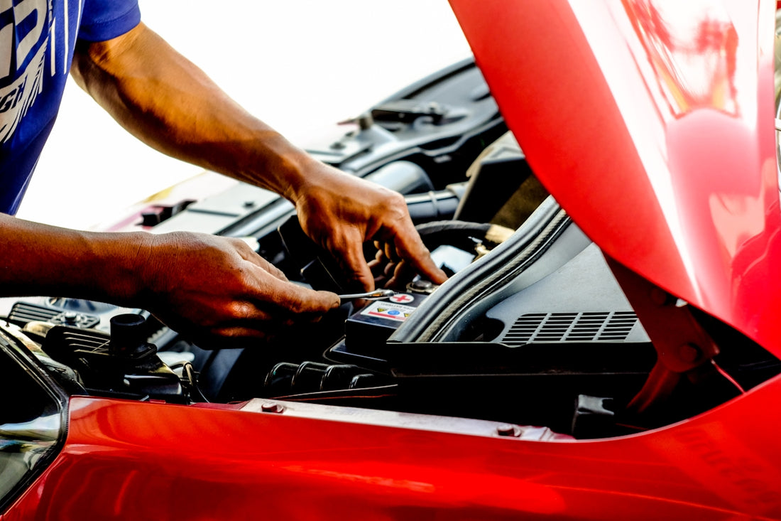 person fixing car during daytime