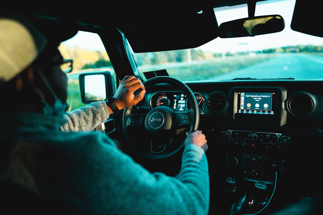 man in gray sweater driving car during daytime