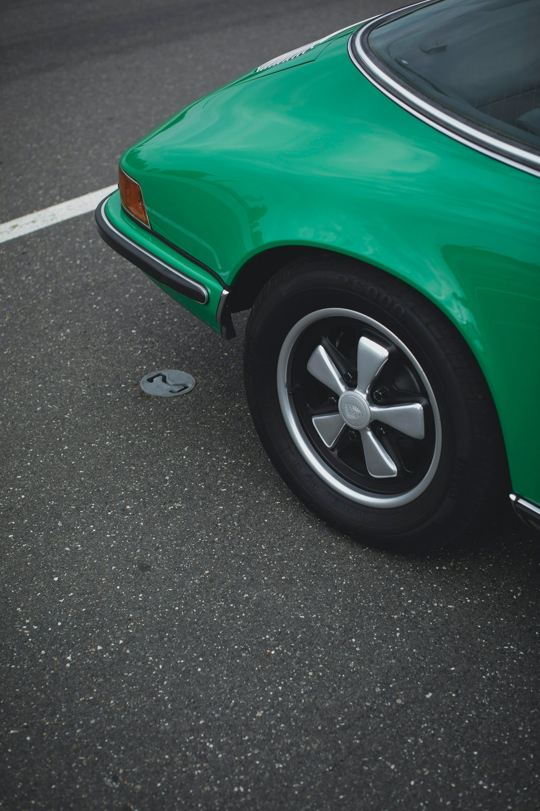 green car on gray asphalt road during daytime