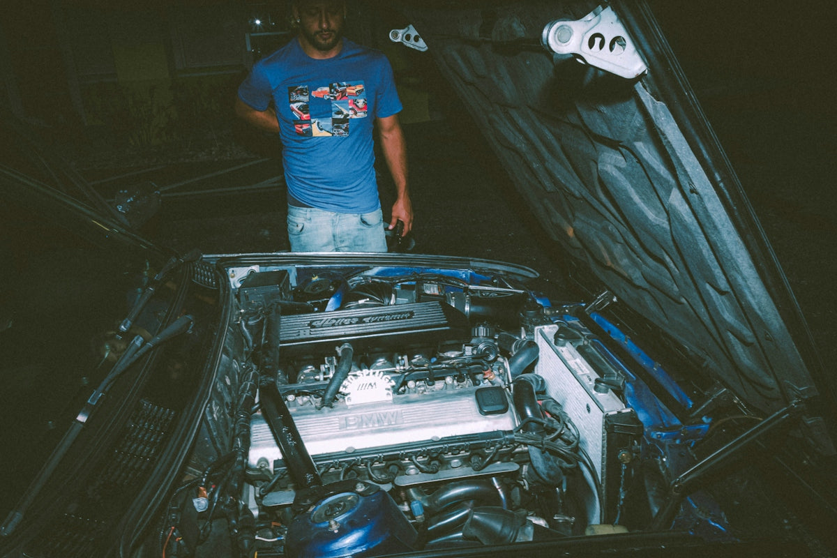 a man standing next to a car engine