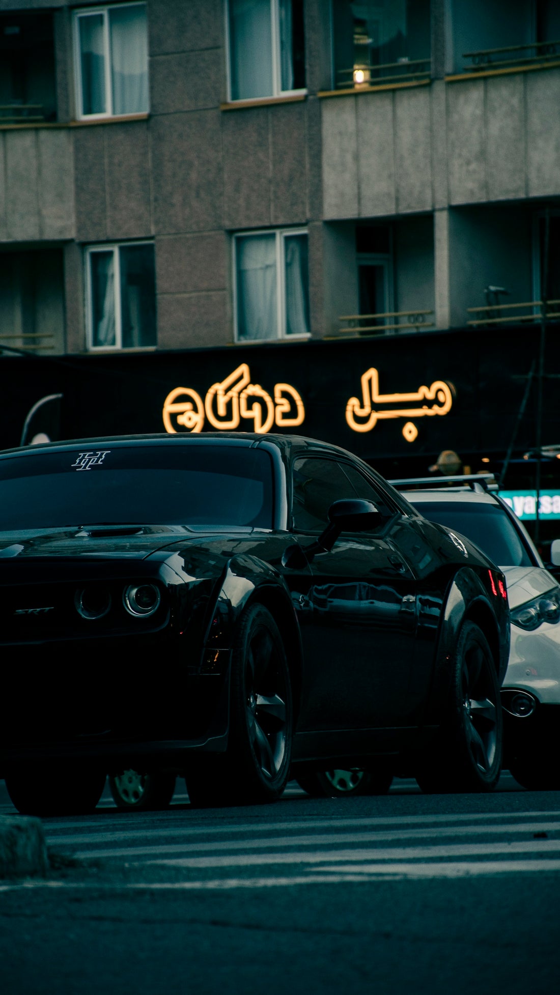 a couple of cars parked next to each other on a street