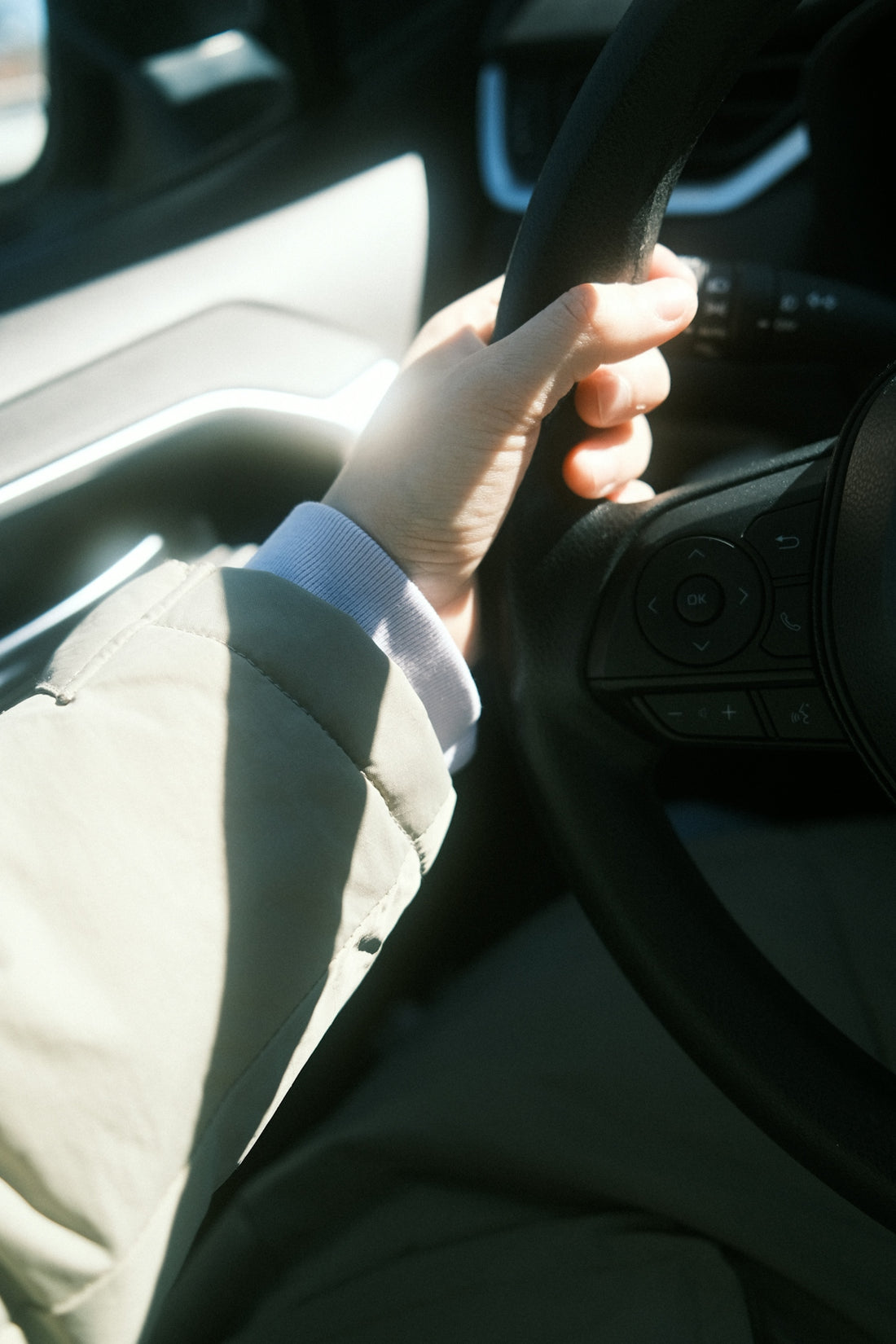 a person holding the steering wheel of a car