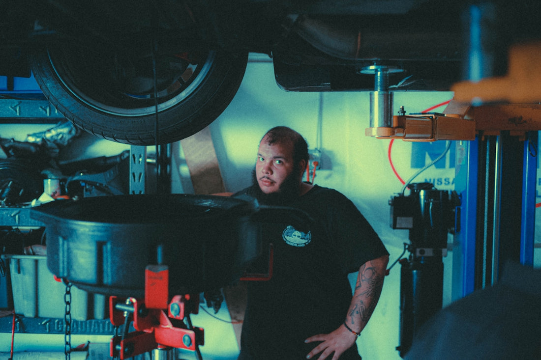 a man standing next to a car in a garage