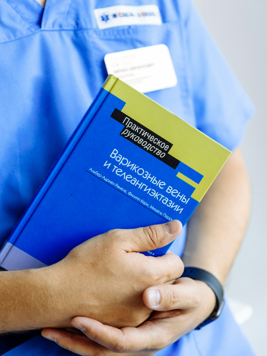 a person in scrubs holding a book in their hands