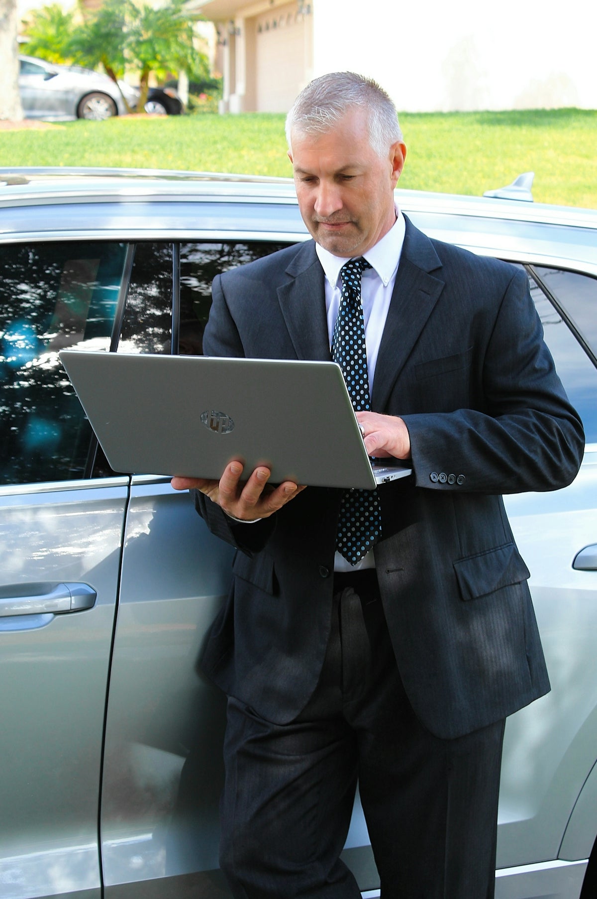 a man in a suit is looking at a laptop