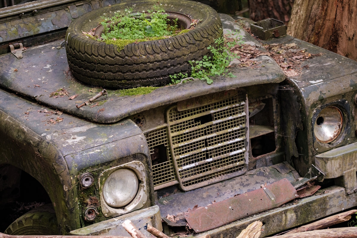 an old truck with a tire on top of it