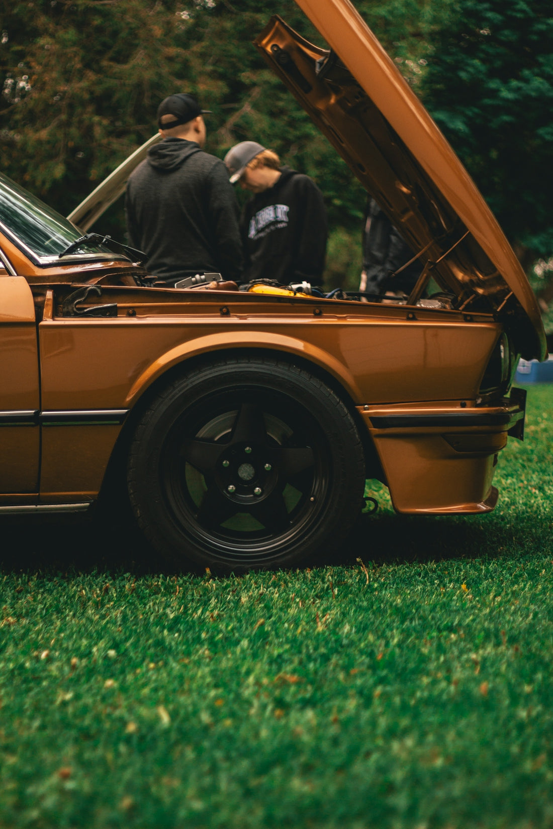 a couple of men standing in the back of a car