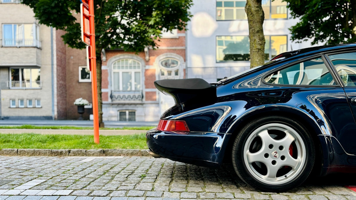 a blue porsche parked on the side of the road