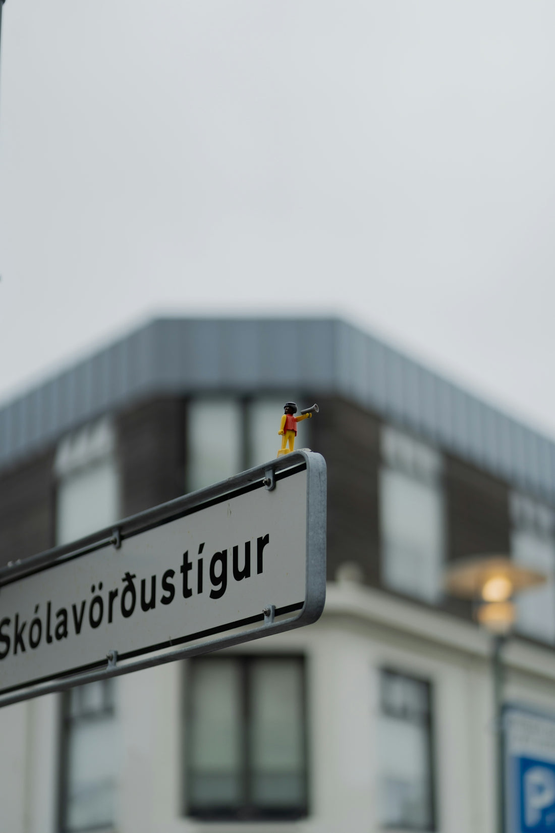 A street sign on a pole in front of a building
