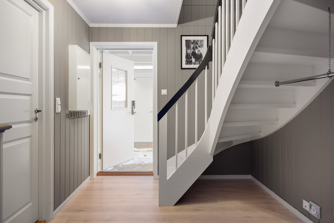 A hallway with a staircase and a picture on the wall