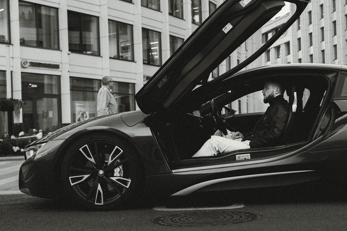 A black and white photo of a car with its doors open