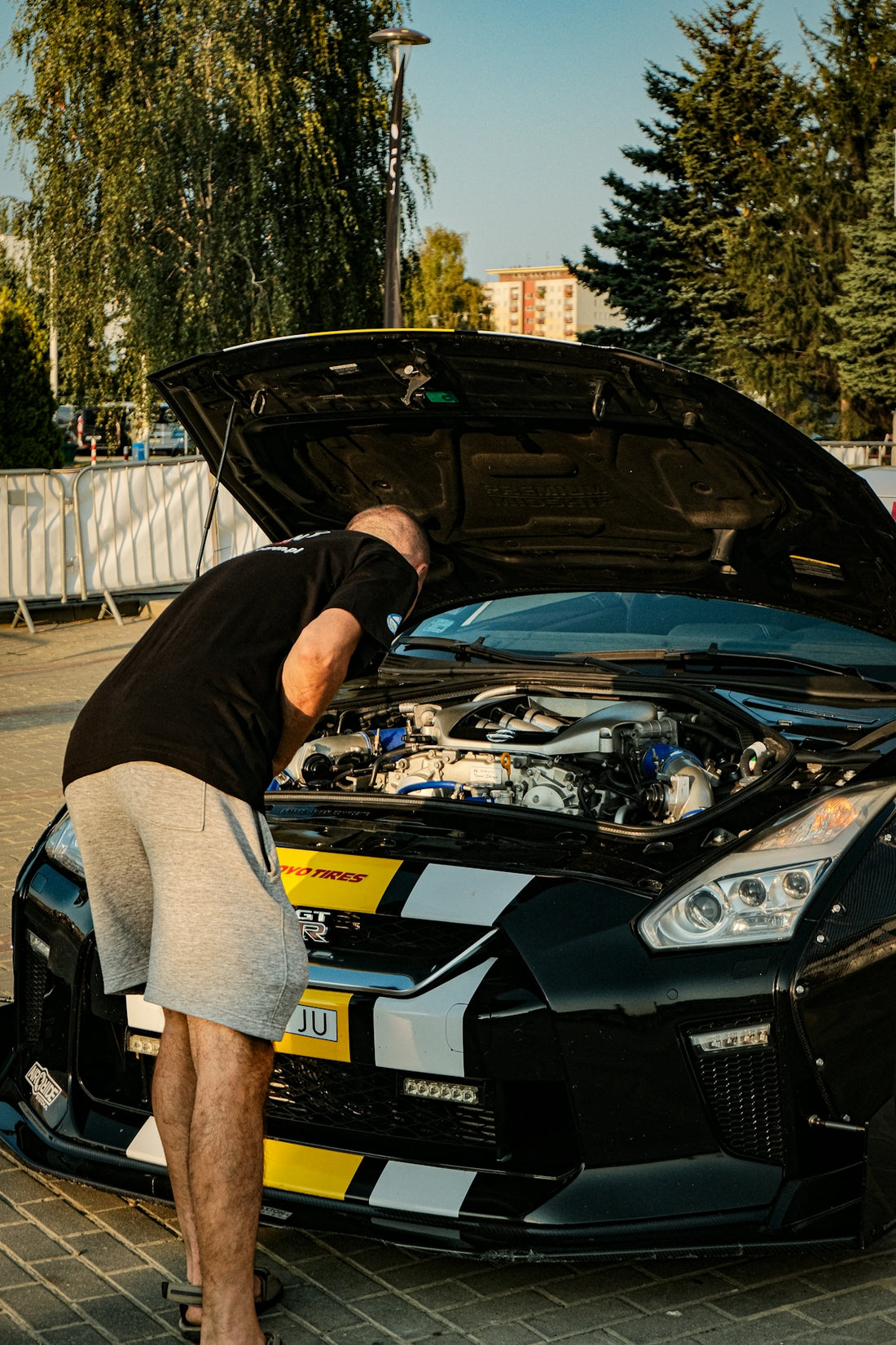 A man standing next to a black sports car