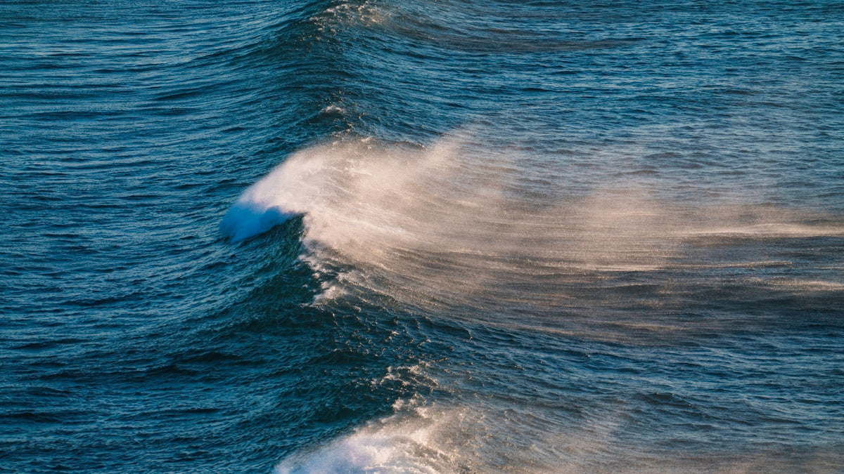 A man riding a wave on top of a surfboard