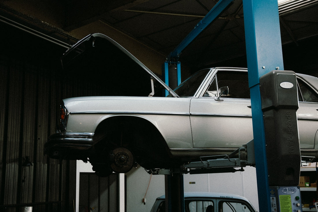 A white car on a lift in a garage