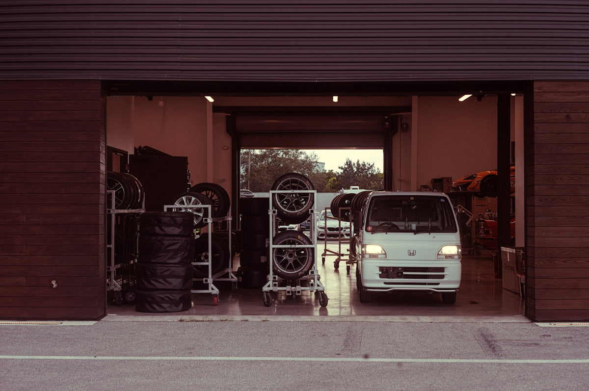 A white van parked in front of a garage