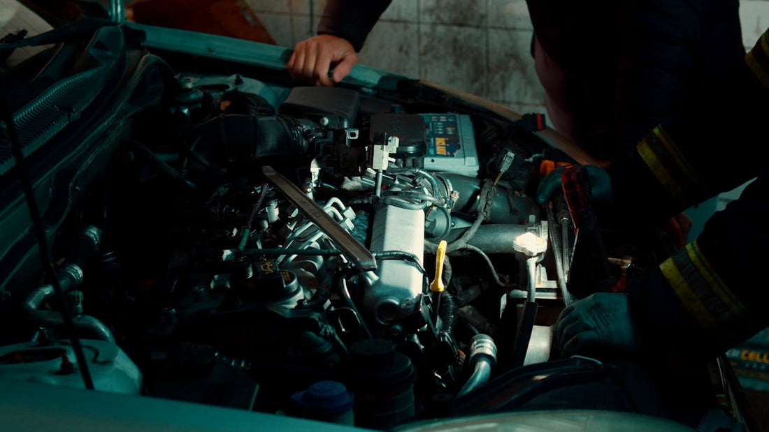 A man working on a car engine in a garage