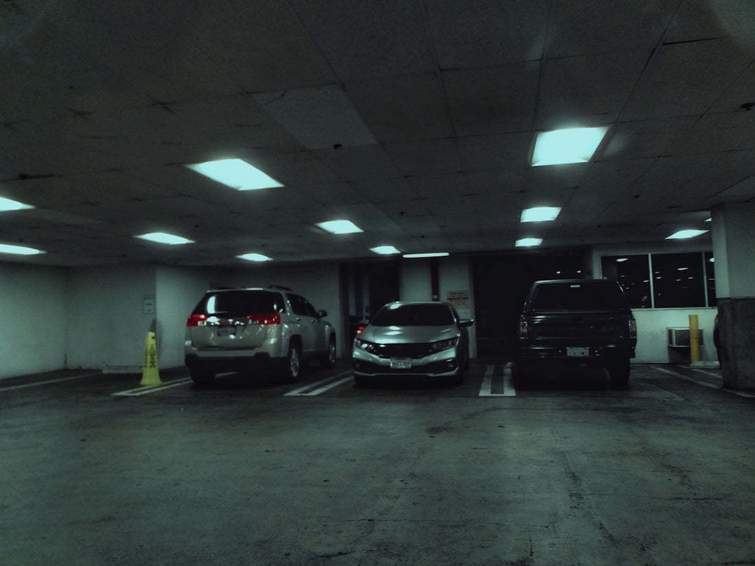 A parking garage with two cars parked in it