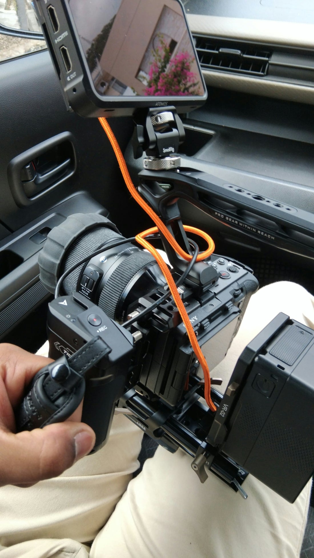 A person holding a camera in a car