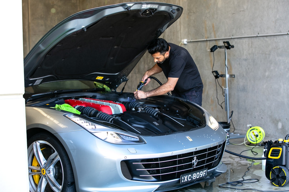 A mechanic is working on a ferrari car.