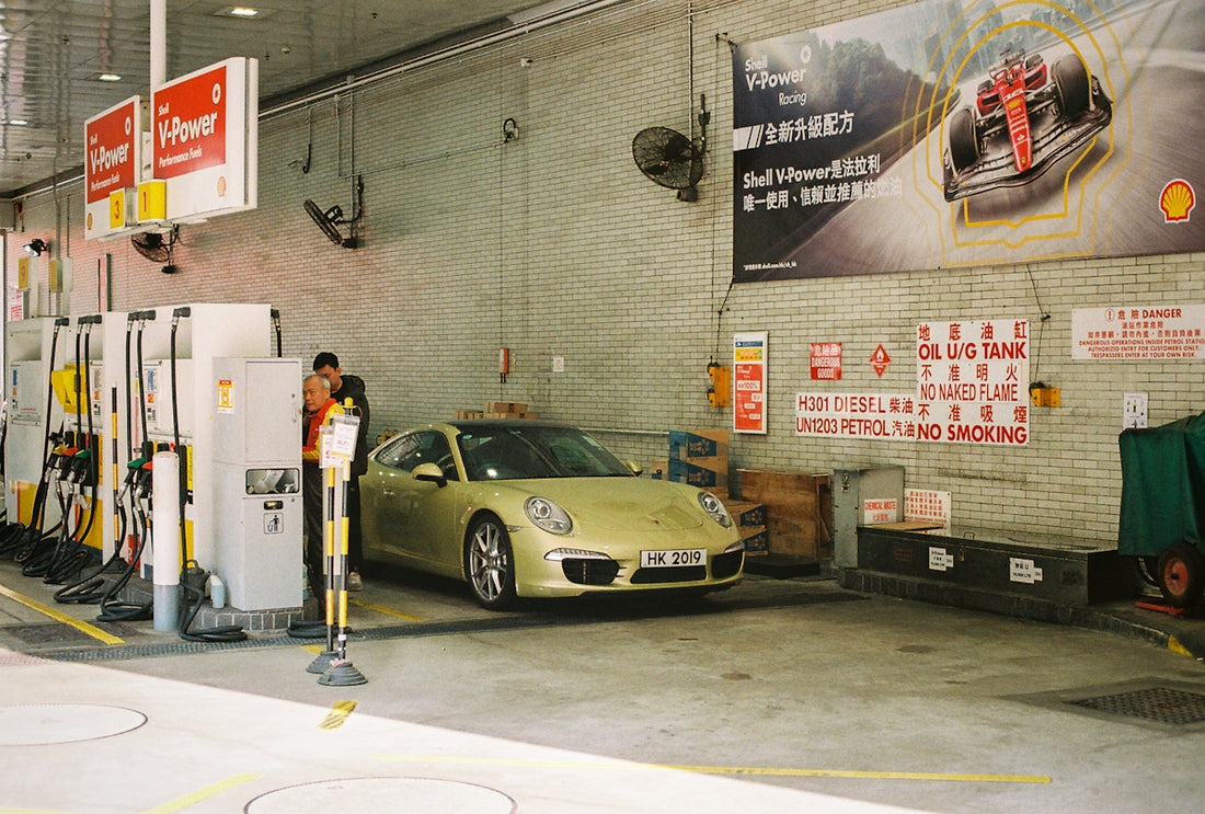 A porsche is refueling at a shell gas station.