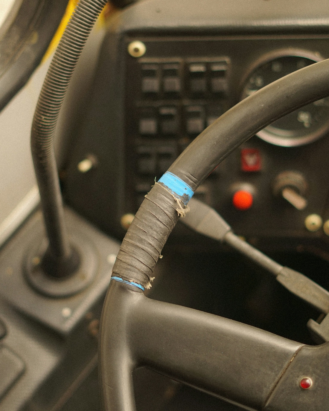 Close-up of a worn steering wheel with tape.