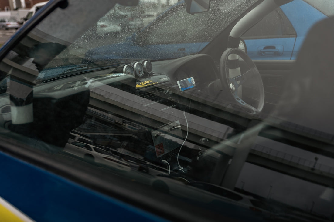 Interior view of a blue car with gauges.