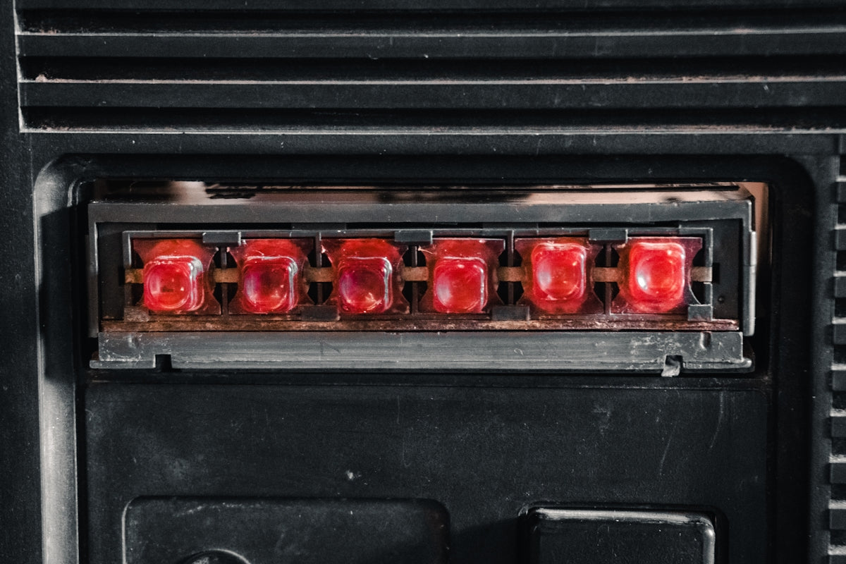 Close-up of six red indicator lights on black panel