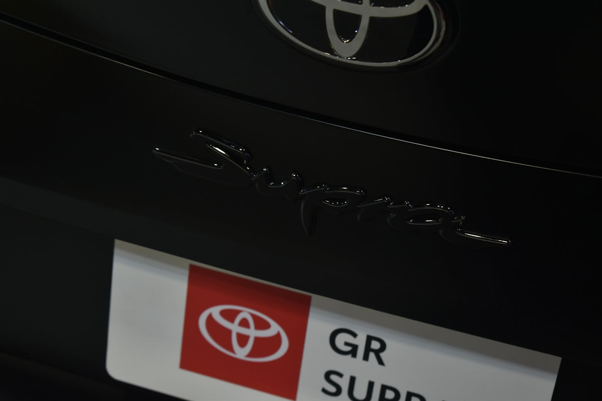 Close-up of a black toyota gr supra emblem