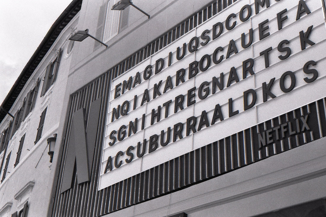 Monochrome building with a netflix sign and scrambled letters.