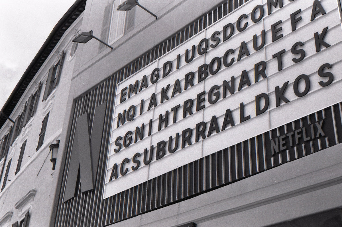 Monochrome building with a netflix sign and scrambled letters.