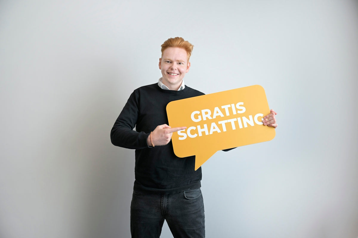 A smiling man holds a gratis schatting speech bubble sign